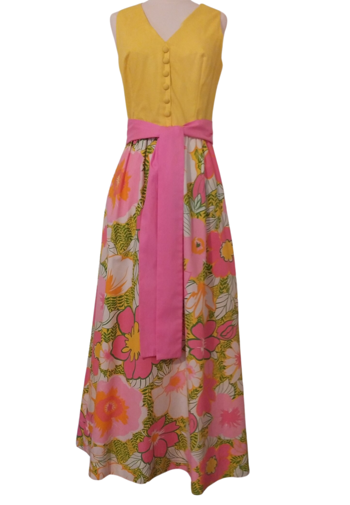 Yellow top floral print dress with pink sash. Vintage style clothing on white